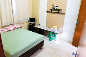 una habitación con una cama y un escritorio con una computadora en Casa com Churrasqueira e Piscina em Camacari BA, en Camassari 19 fotos más