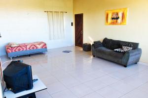 Una sala de estar con dos sofás y un televisor. en Casa com Churrasqueira e Piscina em Camacari BA, en Camassari
