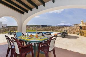 un patio con tavolo e sedie e una piscina di Villa Lira a Cala Morell