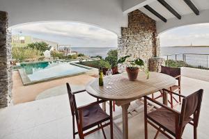 a table and chairs on a patio with a swimming pool at Villa Aire in Punta Prima