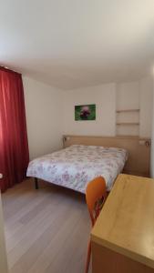 een kleine slaapkamer met een bed en een tafel bij Casa Cappello in Malè