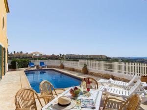 a patio with a table and chairs next to a pool at Villa Fiesta in Cala en Blanes