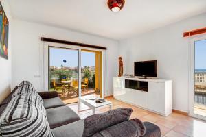 a living room with a couch and a tv at Villa Fiesta in Cala en Blanes