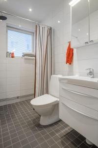 uma casa de banho branca com um WC e um lavatório em Stockholm Checkin Apartment Alvik em Estocolmo