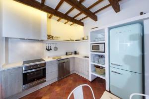シウタデリャにあるSANT ISIDRE 50の白いキャビネットと冷蔵庫付きの広いキッチン