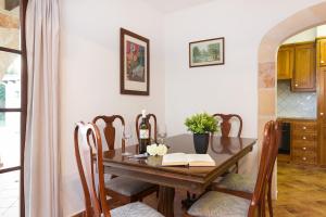 tavolo da pranzo con una bottiglia di vino e un libro di Villa S'Hortal a Ciutadella