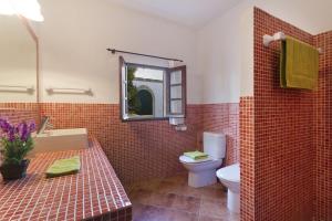 un bagno con un water, un lavandino e uno specchio di Villa S'Hortal a Ciutadella Altre 4 foto