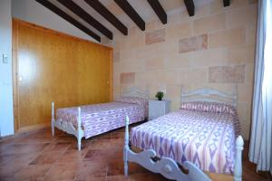 1 dormitorio con 2 camas y pared de ladrillo en Villa S'Hortal en Ciutadella
