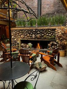 a patio with a fireplace and a table and chairs at Hotel Giardino Di Pietra in Gramado