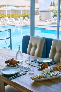 a table with plates of food and a swimming pool at Golden Apartments in Marina di Cecina