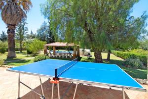 una mesa de ping pong en un patio con cenador en Casa Alcantarilha, en Pêra