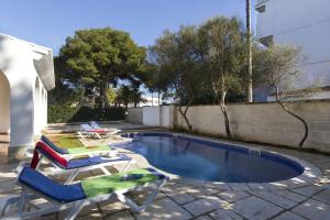 a swimming pool with two lounge chairs and a swimming pool at Villa Gregal in Cala Blanca