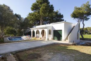 ein weißes Haus mit einem Pool und Bäumen in der Unterkunft Villa Gregal in Cala Blanca