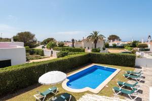 a villa with a swimming pool and lounge chairs at Villa Cristina in Cala en Bosc