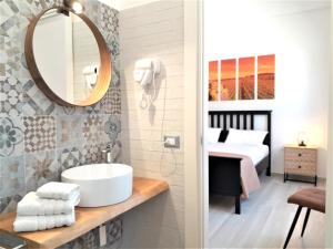 un bagno con lavandino e specchio e una camera da letto di CI VULIA b&b - Sicilia sea, pool, bbq, tv, wi-fi ad Alcamo Marina