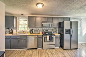 una cocina con armarios grises y electrodomésticos de acero inoxidable en Dog-Friendly Fayetteville Home with Hot Tub!, en Fayetteville