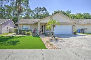 a house with a garage and a palm tree at Tampa Home with Hot Tub about 15 Mi to Downtown! in Tampa