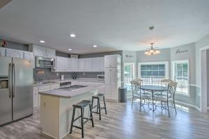 a kitchen with a table and chairs and a kitchen with white cabinets at Charming Ranch-Style Home Near Lake Lanier! in Gainesville