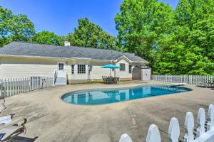 a house with a swimming pool in front of a fence at Charming Ranch-Style Home Near Lake Lanier! in Gainesville