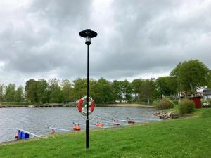 un poste de luz en la hierba junto a un lago en Nice holiday house located by the lake Bolmen en Ljungby