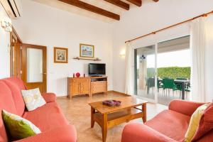 a living room with a couch and a table at Villa S'Aladern in Cala'n Bosch