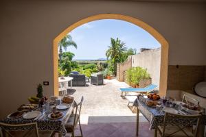 an arched doorway to a patio with tables and chairs at - Vista Egadi - in Torre Nubia
