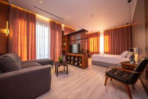 een woonkamer met een bank en een bed bij Area Hotel in Ksamil