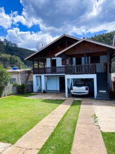 uma casa com um carro estacionado na garagem em Recanto dos Fernandes em Monte Verde