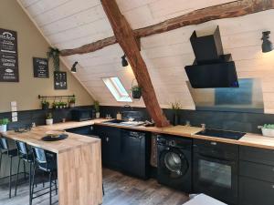 y cocina con lavadora, fregadero y fogones. en gîte le gabizos avec bain nordique et sauna en pleine montagne, en Arrens-Marsous