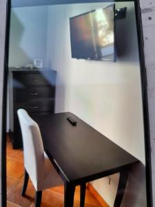 una mesa negra con una silla y un televisor en la pared en Casa Vacanza LA PALMA Selinunte Sicilia, en Marinella di Selinunte