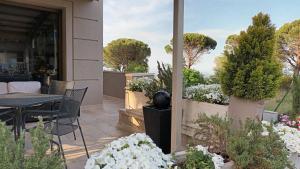 a patio with a table and chairs and flowers at Hotel Tirrenia in Chianciano Terme