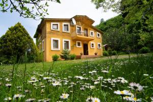 uma casa amarela num campo de flores em Villa River Village em Trebizonda