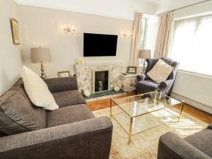a living room with two couches and a fireplace at Burwood in Colwyn Bay