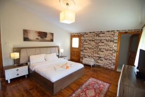 um quarto com uma cama e uma parede de tijolos em Villa River Village em Trebizonda