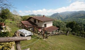 una pequeña casa en la cima de una colina con montañas en Casa Campu 2, en Pandavenes