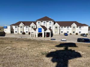 ein Schatten eines Gebäudes vor einem Parkplatz in der Unterkunft Chadron Inn & Suites in Chadron