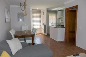 een woonkamer en een keuken met een bank en een tafel bij Apartamento Jardin del Golf in Novo Sancti Petri