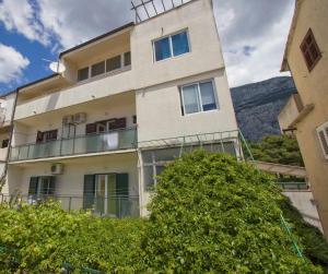 an apartment building with a hill in the background at ARGUSA4 in Makarska