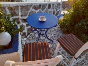 a blue table with two chairs and a cup on it at Mamos Sunset House Plaka in Plaka Milou