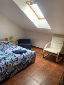 - une chambre avec un lit, une chaise et une lucarne dans l'établissement Penzion L´isola, à Kunžak