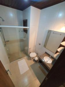 La salle de bains est pourvue d'une douche, de toilettes et d'un lavabo. dans l'établissement Hotel Pousada Capão, à Garopaba