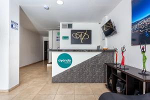 a living room with a tv and a wall at Ayenda Agustin Plaza in Pasto
