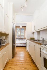 cocina con armarios blancos y suelo de madera en Stockholm Checkin Apartment Fridhemsplan, en Estocolmo