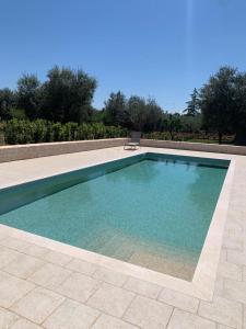 - une piscine d'eau bleue dans la cour dans l'établissement Il Villino di GRAZIO, à Monopoli