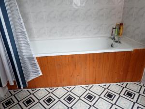 a bath tub in a bathroom with a tiled floor at Charming Kintbury Cottage in Kintbury