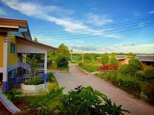 an empty street next to a house at บ้านสวนชนะจน in Fang