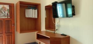 a room with a tv on the wall and a closet at บ้านสวนชนะจน in Fang