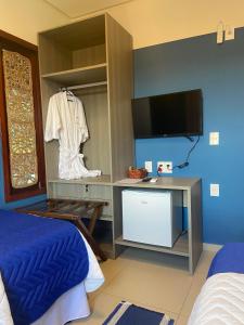 um quarto com uma cama e uma televisão num quarto em Caminho da Praia BG em Barra Grande