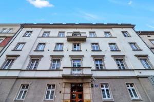 duży biały budynek z oknami i balkonem w obiekcie Ariańska apartment - Cracow, city centre w Krakowie