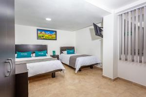 1 dormitorio con 2 camas y TV. en Ayenda Agustin Plaza, en Pasto